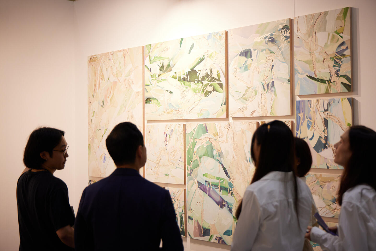 Collectors looking at artwork - 2 paintings of a cartoon business man