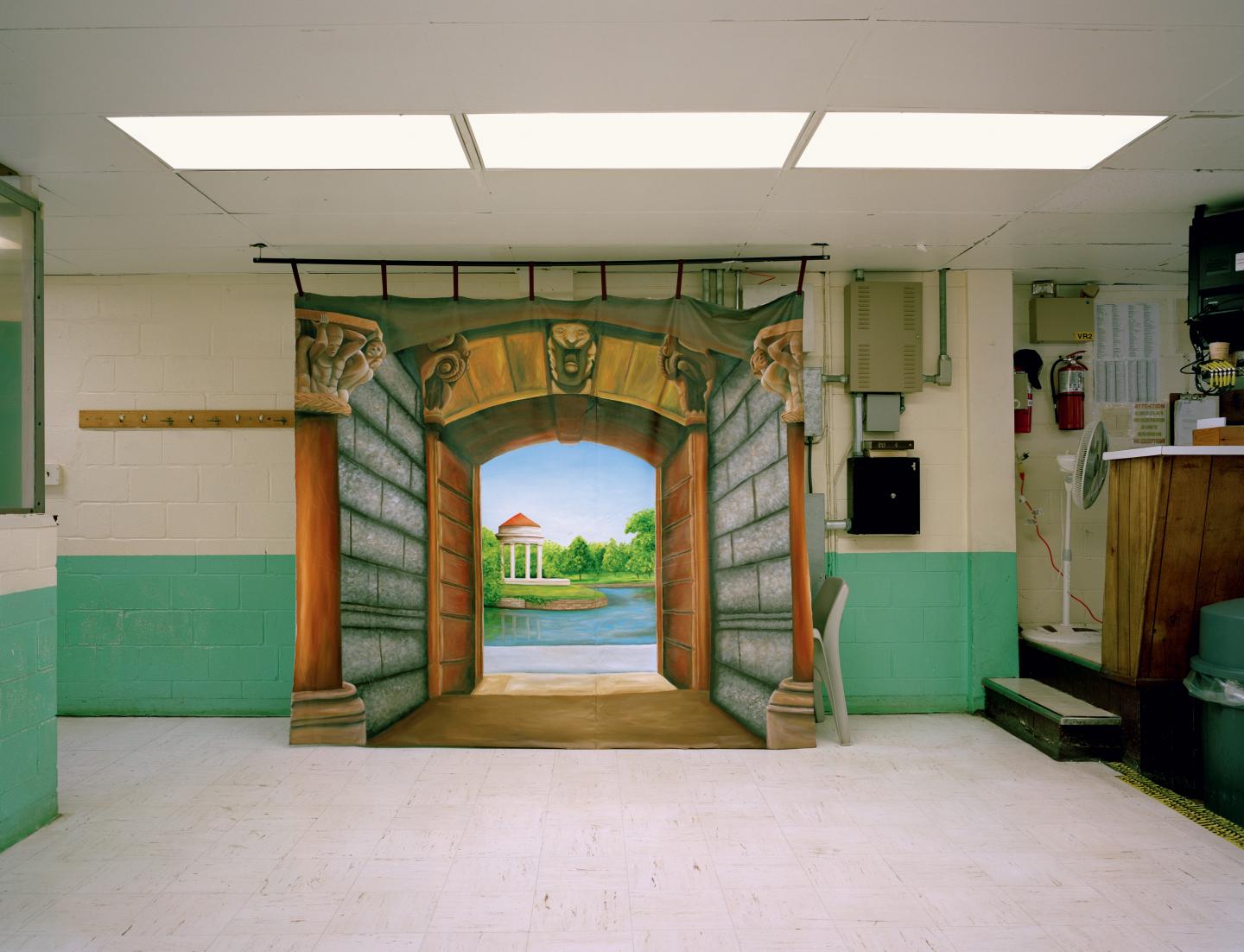 Painting of landscape with gates placed in sterile prison environment