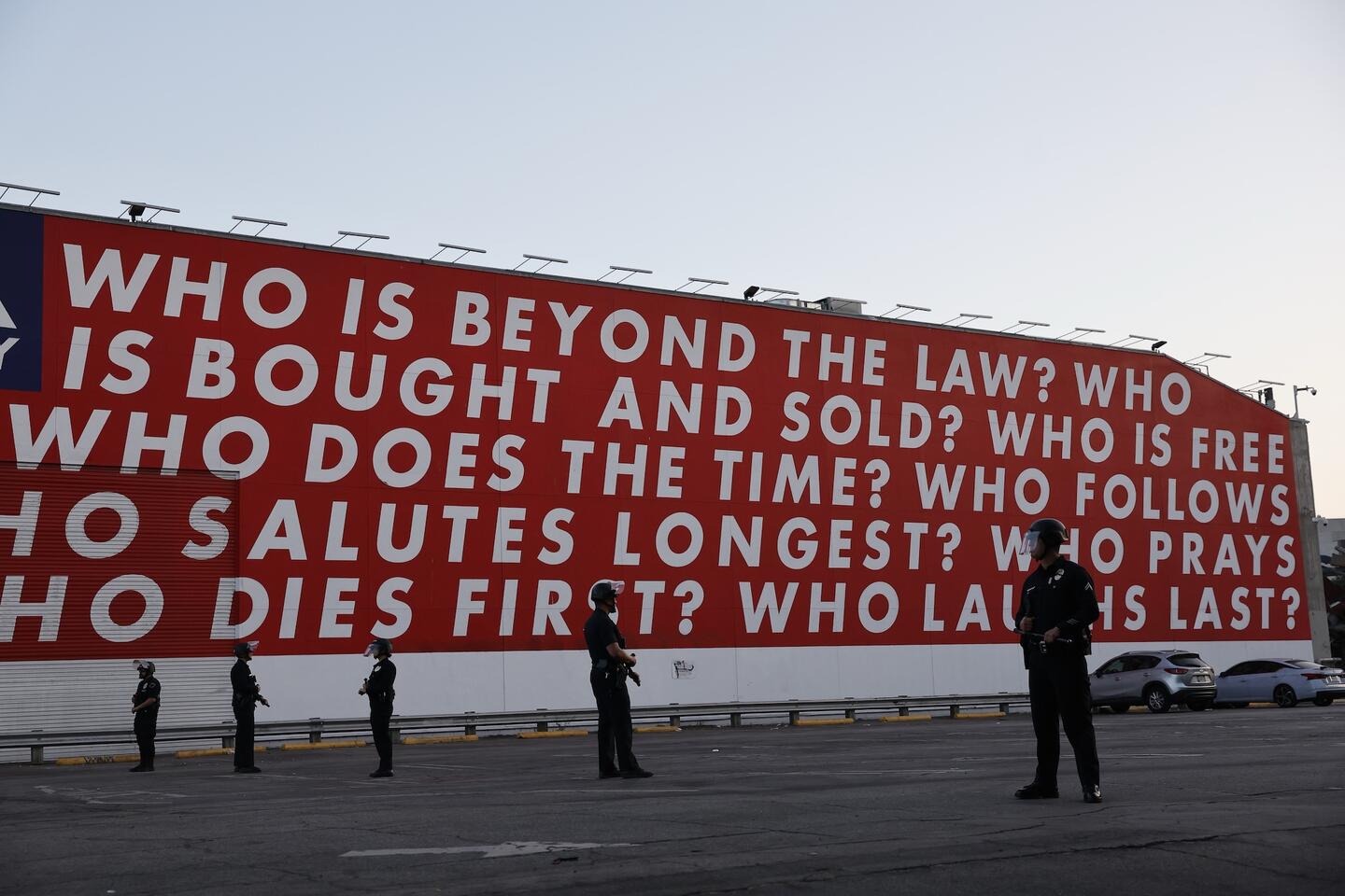LAPD officers form a police line in a parking lot in front of an iconic mural near Temple and Alameda Streets downtown Thursday, June 12, 2025, in Los Angeles, CA. (Gina Ferazzi / Los Angeles Times via Getty Images) 