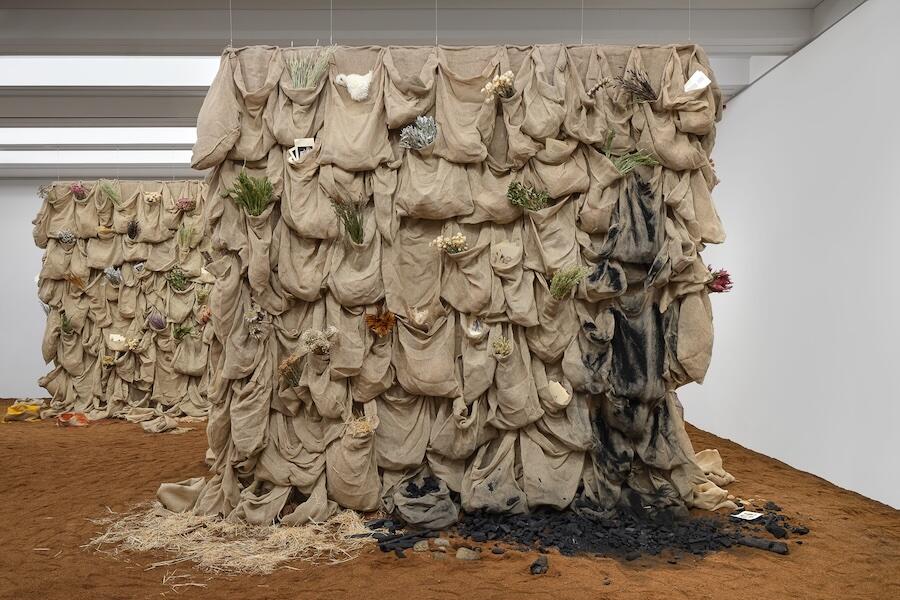 Brown linen sacks filled with soil, paper, plants...