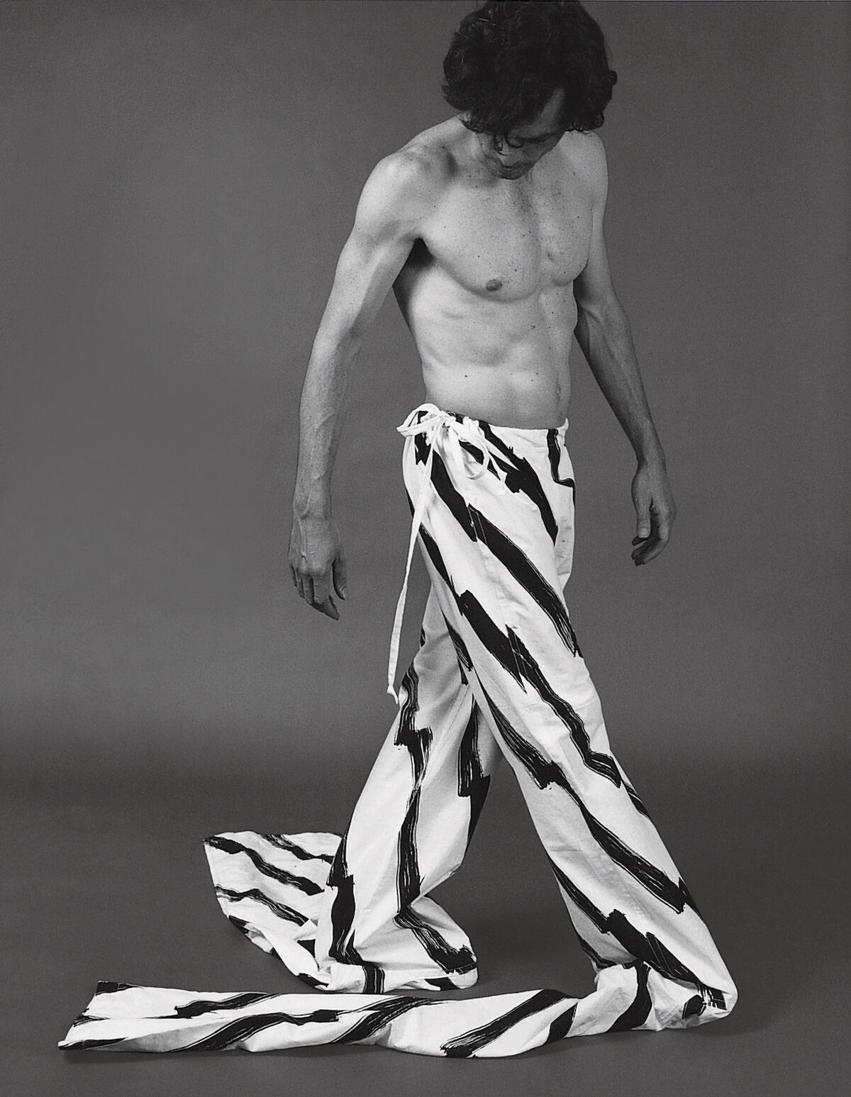 Topless man in fabric trousers, monochrome photograph