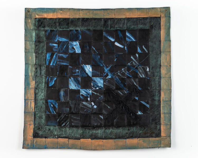 A dark square blanket with blue-black center and lighter edge