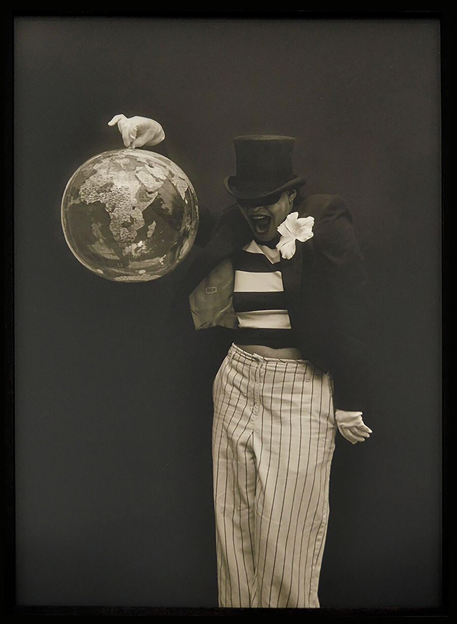 Clown holds an inflatable globe.