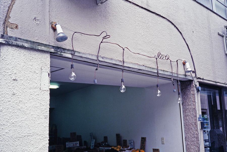 A photograph of looping wires attached to lightbulbs above a doorway