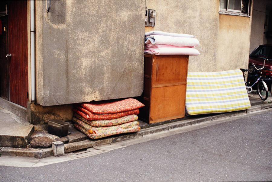 Neatly ordered stacks of clothing next to an outdoor wall