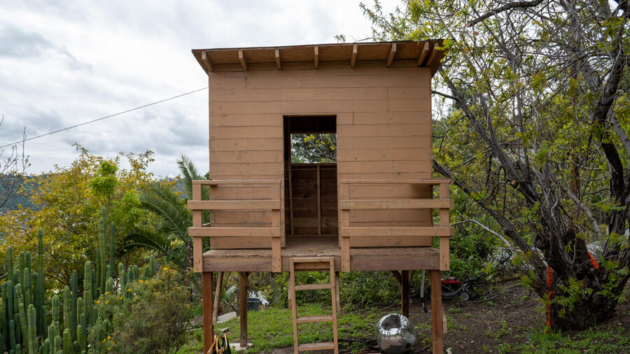 A wooden treehouse set atop a hill