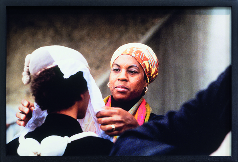 Woman adjusting another woman's veil.