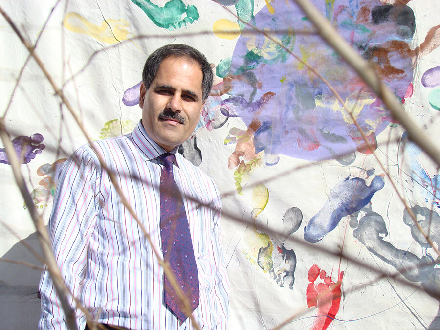 Rahraw Omarzad with a painting created by women artists at the CCAA